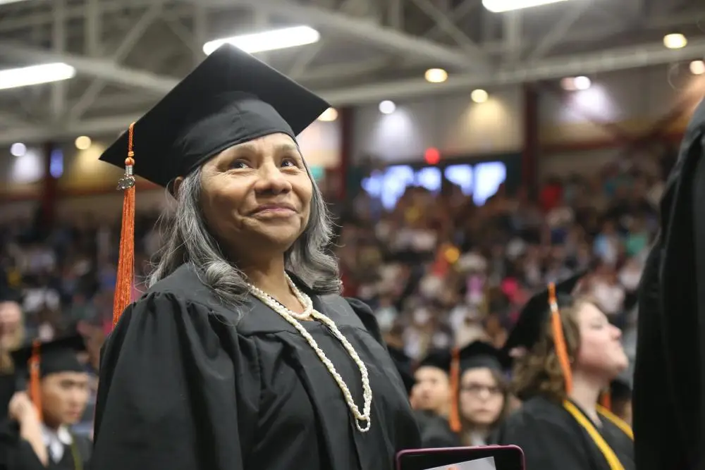 student in cap and gown at ceremony